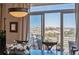 A well-lit dining room features an outdoor view of the distant landscape and patio seating at 11064 Hermitage Run, Littleton, CO 80125