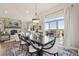 An open-concept dining room with natural light, decorative rug, and a stone fireplace in the background at 11064 Hermitage Run, Littleton, CO 80125
