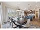 An open-concept dining room features stylish furniture, a modern chandelier, and plantation shutters at 11064 Hermitage Run, Littleton, CO 80125