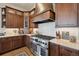 A gourmet kitchen features a professional range, custom vent hood, and designer finishes at 11064 Hermitage Run, Littleton, CO 80125