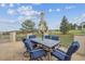 Outdoor dining set with comfortable blue chairs and scenic backyard view at 11064 Hermitage Run, Littleton, CO 80125