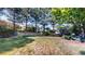 Landscaped backyard with a stone retaining wall surrounded by mature trees and lush greenery offering a private outdoor space at 1977 Champions Cir, Castle Rock, CO 80104