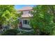 Backyard view of home with a well-manicured lawn, mature trees, patio and deck perfect for outdoor living and relaxation at 1977 Champions Cir, Castle Rock, CO 80104