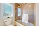 Bathroom with glass enclosed tub shower, window, and a toilet with gold fixtures at 1977 Champions Cir, Castle Rock, CO 80104
