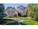 Charming home featuring manicured lawn, stone accents and mature trees at 1977 Champions Cir, Castle Rock, CO 80104