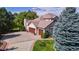 Aerial shot of a home featuring a well-manicured lawn, mature trees, and a spacious driveway leading to a two-car garage at 1977 Champions Cir, Castle Rock, CO 80104
