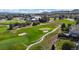 Scenic aerial view of a well-maintained golf course, featuring lush greenery, sand traps, and a nearby clubhouse at 1977 Champions Cir, Castle Rock, CO 80104