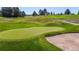 Close up image of the green on a well-maintained golf course, showcasing the lush green grass and sand trap at 1977 Champions Cir, Castle Rock, CO 80104
