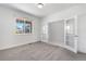 Bright bedroom featuring neutral walls and carpet, a window with neighborhood views, and adjacent glass paneled doors at 6387 Agave Ave, Castle Rock, CO 80108