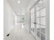 Bright hallway features tile floors, white walls and glass paneled doors with a glimpse into a sunlit room at 6387 Agave Ave, Castle Rock, CO 80108