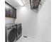 Well-organized laundry room with appliances, storage cabinets, and a hanging rack at 6387 Agave Ave, Castle Rock, CO 80108