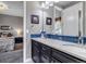 Bathroom features a dual vanity with blue backsplash and a view into the primary bedroom at 6746 S Biloxi Ct, Aurora, CO 80016