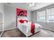 Cozy bedroom with a modern ceiling fan, large windows, and a decorative red floral accent wall at 6746 S Biloxi Ct, Aurora, CO 80016