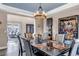 Elegant dining area with large table, statement lighting, and view to living area at 6746 S Biloxi Ct, Aurora, CO 80016