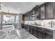 Beautiful kitchen featuring dark wood cabinets, a granite countertop, and a view of the backyard through a bright window at 6746 S Biloxi Ct, Aurora, CO 80016