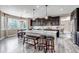Spacious kitchen featuring a large island with seating, dark wood cabinets, and modern pendant lighting at 6746 S Biloxi Ct, Aurora, CO 80016