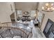 Spacious living room with grand staircase, beautiful chandelier, hardwood floors, and large windows for plenty of natural light at 6746 S Biloxi Ct, Aurora, CO 80016