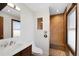 Bright bathroom featuring a modern vanity, toilet, and shower with wood-like tile and pebble floor at 2154 S Joplin Way, Aurora, CO 80013