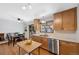 View of kitchen with stainless appliances, light wood cabinets and adjacent dining table at 2154 S Joplin Way, Aurora, CO 80013