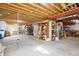 Unfinished basement area with exposed wooden ceiling, support beams, and ample storage space at 4305 Easley Rd, Golden, CO 80403