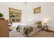 Sunlit bedroom showcasing a comfortable bed, natural light from outside, and a cozy workspace with a desk at 4305 Easley Rd, Golden, CO 80403