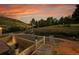 Backyard featuring landscaping, lawn, stone patio, mountain views, and sunset at 5808 Crestbrook Cir, Morrison, CO 80465