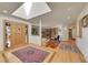 Bright foyer with hardwood floors, a skylight, an elegant rug, and a stained-glass front door at 5808 Crestbrook Cir, Morrison, CO 80465