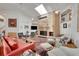 Bright living room with a brick fireplace, skylight, ceiling fans, and elegant decor at 5808 Crestbrook Cir, Morrison, CO 80465