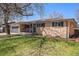 This brick home features an attached garage and cozy front porch at 241 S 15Th Ave, Brighton, CO 80601