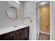 Bathroom featuring a modern vanity with round mirror and an open doorway to the toilet at 2181 S Troy Way # 103, Aurora, CO 80014