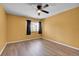 Well-lit bedroom with ceiling fan, wood-look floors, and a window with curtains at 2181 S Troy Way # 103, Aurora, CO 80014