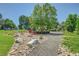 Community area with red park bench surrounded by trees and a rock garden at 2181 S Troy Way # 103, Aurora, CO 80014