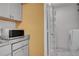 Laundry room with marble tile, grey cabinets, microwave, and pantry rack at 2181 S Troy Way # 103, Aurora, CO 80014