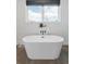 A freestanding tub sits beneath a window, creating a bright and relaxing bathroom space at 285 Clementina St, Louisville, CO 80027