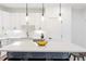 Bright kitchen with white cabinets, stylish island, and modern fixtures at 285 Clementina St, Louisville, CO 80027