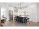 Open concept kitchen with large island, stainless appliances, and modern lighting fixtures at 285 Clementina St, Louisville, CO 80027