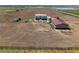 Expansive aerial view of home, farm, and outbuildings on acreage with lake views in the distance at 3160 Bella Rosa Pkwy, Longmont, CO 80504