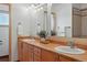 Bathroom features a double sink vanity with warm wood cabinets and a large mirror above at 3160 Bella Rosa Pkwy, Longmont, CO 80504