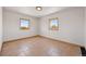 Neutral bedroom features tile floor, neutral walls, and two windows providing ample natural light and outside views at 3160 Bella Rosa Pkwy, Longmont, CO 80504
