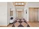Bright foyer featuring a tiled floor, high ceiling, wooden front door, and modern light fixtures at 3160 Bella Rosa Pkwy, Longmont, CO 80504
