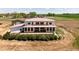 View of the home's rear exterior featuring a large wooden deck, multiple windows and farmland at 3160 Bella Rosa Pkwy, Longmont, CO 80504