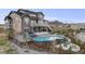 Expansive backyard featuring a custom pool, hot tub, slide, fire pit, and mature trees for privacy at 8750 Red Primrose St, Franktown, CO 80116