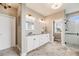 Well-lit bathroom featuring a dual sink vanity, glass-enclosed shower, and scenic outdoor views from the window at 8750 Red Primrose St, Franktown, CO 80116