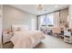 Inviting bedroom with a soft pink bed, a decorative light fixture, and a view from the window at 8750 Red Primrose St, Franktown, CO 80116