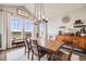 Charming dining room with a rustic wooden table, upholstered chairs, and a stylish light fixture at 8750 Red Primrose St, Franktown, CO 80116