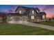 Stunning two-story home featuring a three-car garage, stone accents, and beautifully landscaped front yard at 8750 Red Primrose St, Franktown, CO 80116