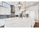 Gorgeous kitchen featuring a large island with white cabinets, stainless steel appliances, and decorative pendant lighting at 8750 Red Primrose St, Franktown, CO 80116