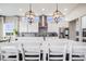 Bright, modern kitchen with a spacious island, pendant lighting, stainless steel appliances, and decorative tile backsplash at 8750 Red Primrose St, Franktown, CO 80116