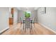 Bright dining room featuring wood floors, modern lighting, and a view of nature outside the large window at 11383 Oakland Dr, Commerce City, CO 80640