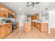 Bright kitchen with wood cabinets, stainless steel appliances, a large island, and hardwood floors at 11383 Oakland Dr, Commerce City, CO 80640